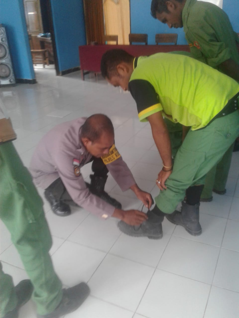 Foto. Anggota Bhabinkamtibmas Polsek Amarasi, Pospol Amarasi Barat  memberikan contoh mengikat sepatu yang benar kepada anggota Linmas  Desa Toobaun.