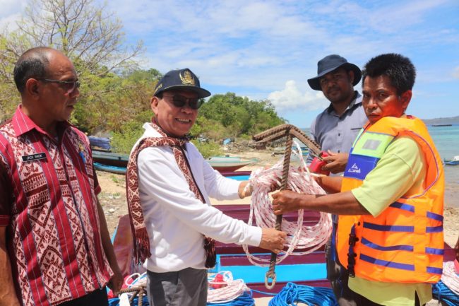 Foto. Bupati Kupang Korinus Masneno, menyerahkan 10 unit perahu motor kepada 20 kelompok penerima bantuan pada Kampung Perikanan Budidaya Laut yang tersebar di 4 (empat) Desa pesisir di Kecamatan Semau, Kabupaten Kupang.