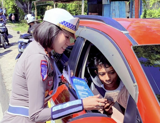 Foto. Petugas Satlantas Polres Kupang membagikan coklat dan brosur keselamatan kepada pengendara pada Operasi Keselamatan Turangga 2025.