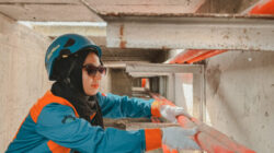 Anisa Salsabila memakai helm dan wearpack saat bertugas di Gardu Induk Kupang.