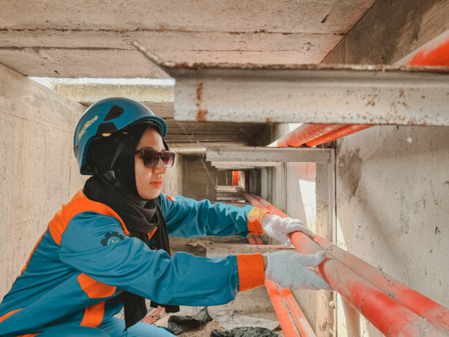 Anisa Salsabila memakai helm dan wearpack saat bertugas di Gardu Induk Kupang.