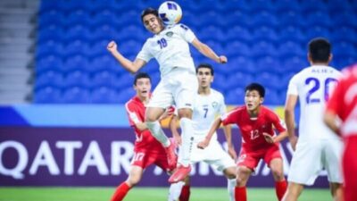 Gambar Kiper Korea Utara berjibaku: Jong Hyon-Ju gagal menghalau sundulan tajam pemain Uzbekistan.