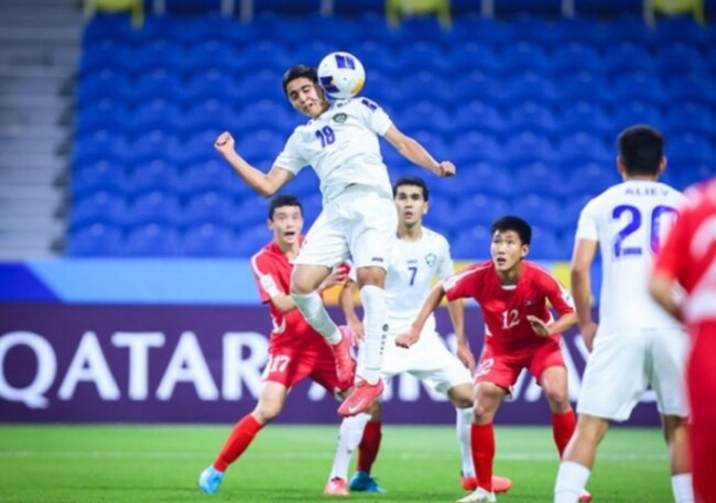 Gambar Kiper Korea Utara berjibaku: Jong Hyon-Ju gagal menghalau sundulan tajam pemain Uzbekistan.